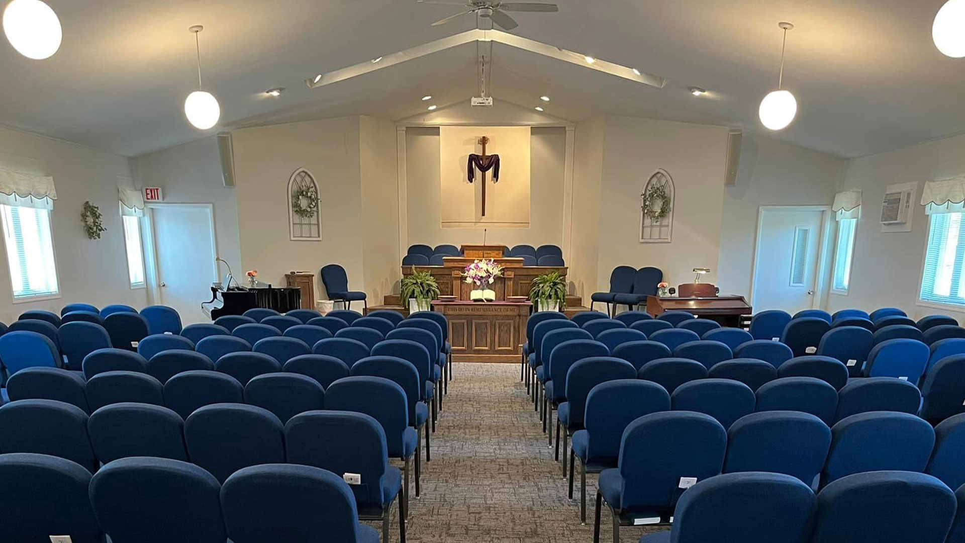 Iglesia Bautista Madison santuario vacío con sillas azules y púlpito central