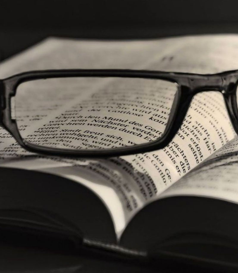 Biblia abierta con gafas de lectura que iluminan 1 Corintios 6:11